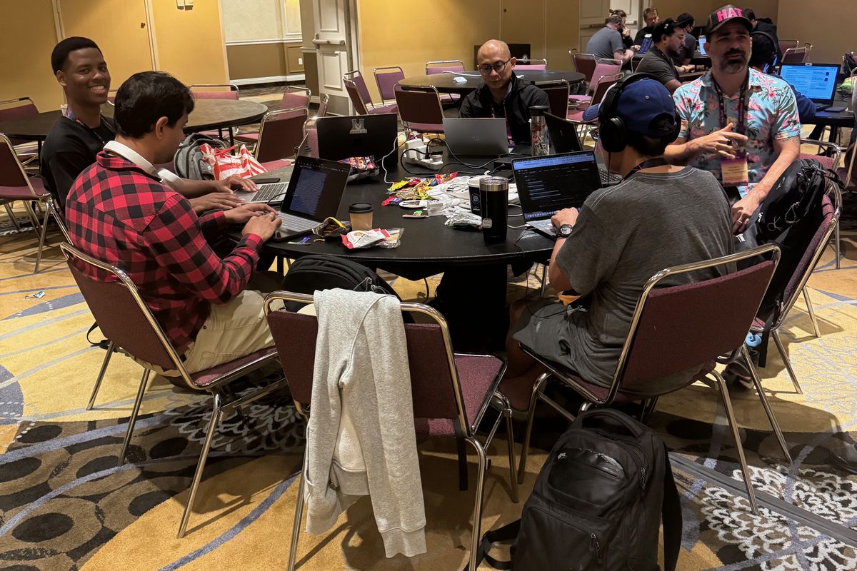 Five people working on laptops around a round table at the Marcus sprint during PyCon US 2026